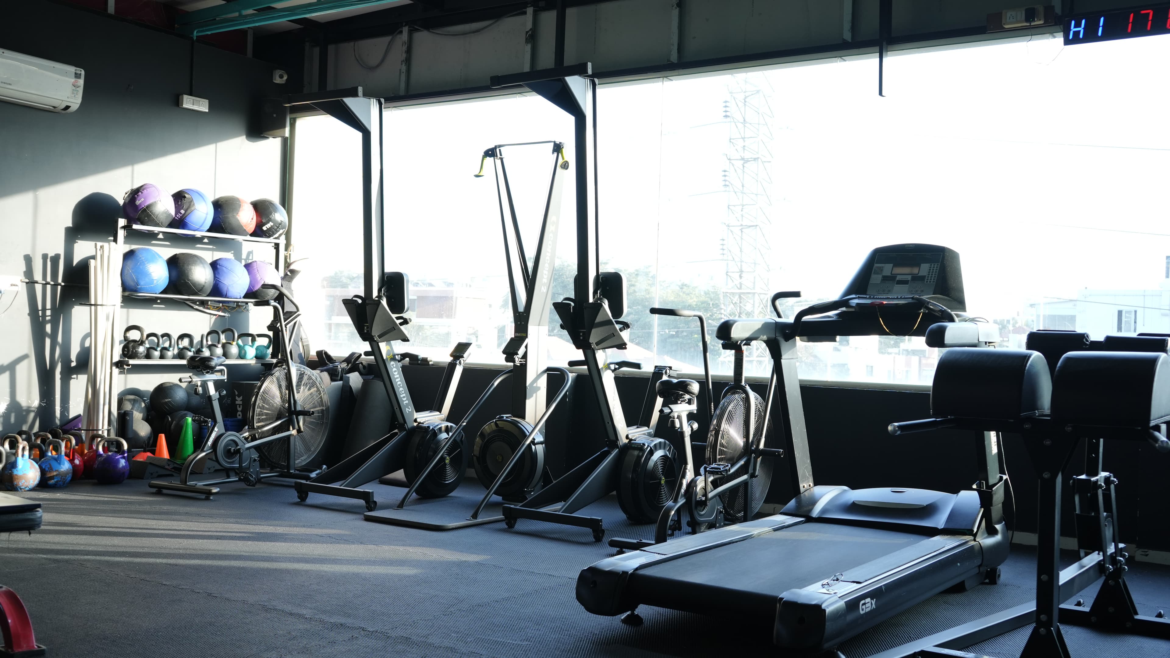 Cardio and conditioning zone at Xthrive HSR Layout with assault bikes, rower, and treadmill for metabolic workouts.